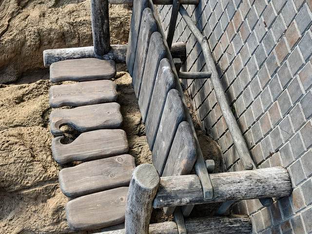 Лестница из брёвен, встроенная в рельеф у подпорной стены